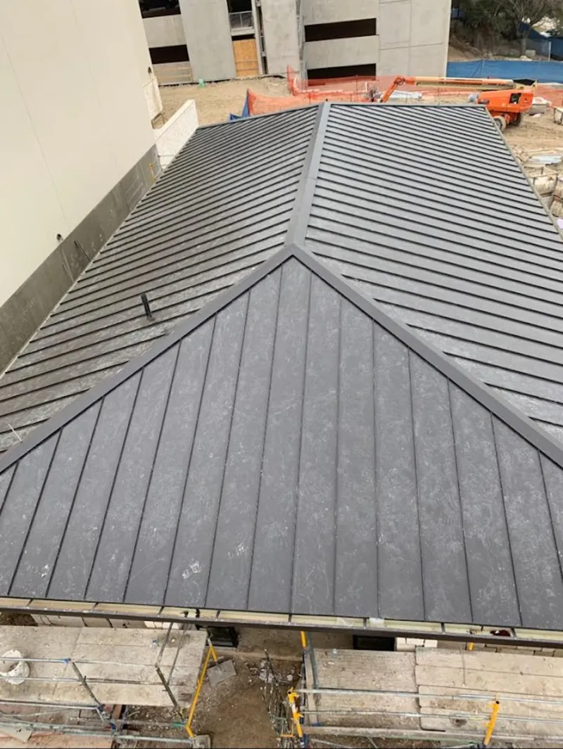 Commercial metal roof construction with crane equipment in Henderson