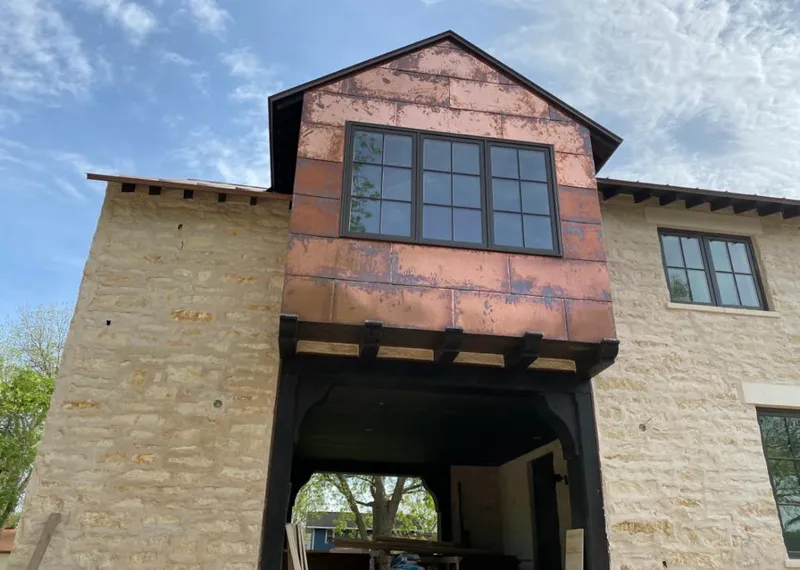 Copper metal panel facade on a stone building for Roof Repair in Henderson